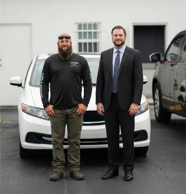 Two Rossen Law attorneys standing by vehicle
