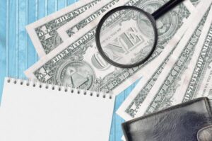 Billete de dólar falsificado bajo una lupa