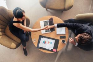 Personas estrechando la mano en una mesa