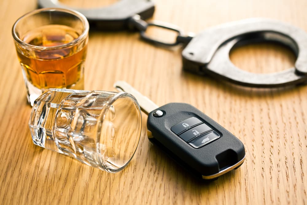 A glass of Alcohol along with hand cuffs and car key- Concept of Drunk Driving